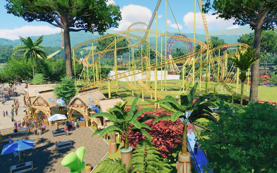 Een panorama van een Tropisch Park, in Resort-stijl. Links ligt een horecapunt met Winkeltjes; rechtsachteraan staat een Achtbaan. Doorheen de balken van de Achtbaanondersteuning is een Radius-Reuzenrad te zien. Tropische beplanting, met onder andere palmbomen, zorgt voor Decoratie.