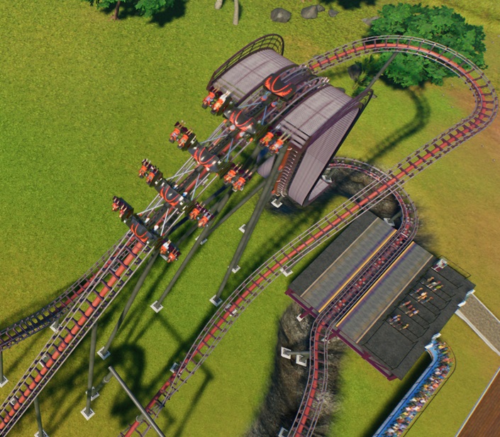 Bovenaanzicht van de 'Lifthill' en de eerste Val. De Trein werd net opgetakeld en begint nu aan De Grote Val. De Trein lijkt op die van een Wing-Achtbaan, in die zin dat de zitplaatsen naast de Baan hangen. De Bezoekers werden met stoel en al ondersteboven gedraaid. De Achtbaan is rood, met donkerbruine dwarsliggers en witte accenten. De Trein bestaat uit vier vierpersoonskarretjes en is zwart, met rode lijnen en beugels. De Trein beweegt zich naar links.