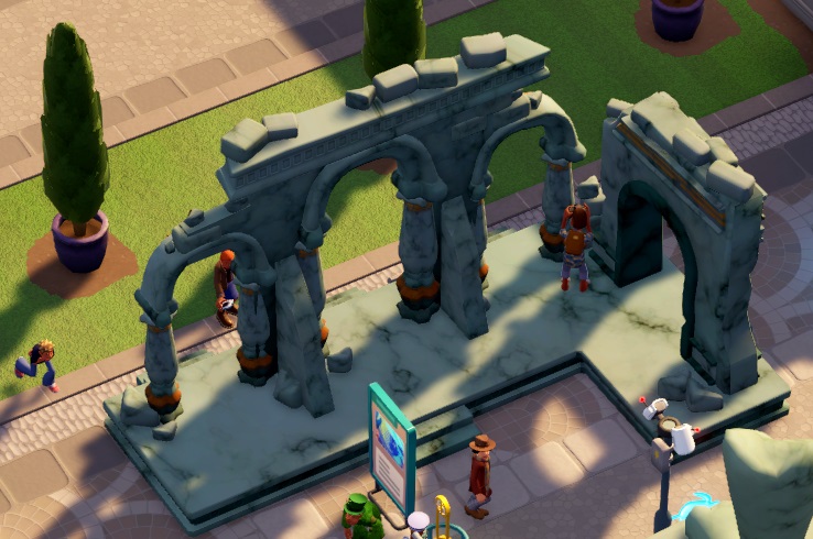 De Archway Ruins bestaan uit drie gewelven, met een boog overbrugd, en haaks daarop een vierde booggewelf. Bezoekers lopen rond en tussen de ruïnes. Onderaan zijn een Infostand en een Veiligheidscamera zichtbaar.