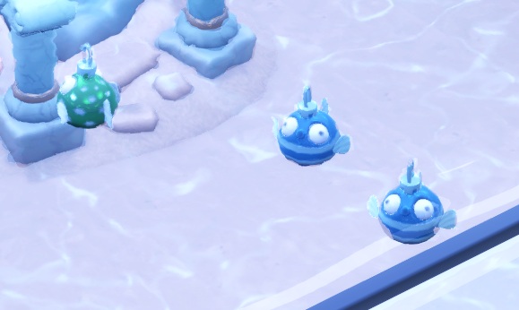 Drie Bauble Fishes in een Aquarium (één groenblauw visje links, twee lichtbaluwe vissen rechts). De Bauble Fish ziet eruit als een zwemmende Kerstbal-met-oogjes-en-vinnen-erop.