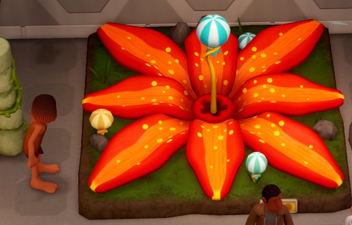 De Blooming Buffoon heeft acht grote, oranjeroodgestreepte kroonbladeren, en een blauw/witgestreepte bal op de stamper. Een Holbewoner kijkt toe van links.