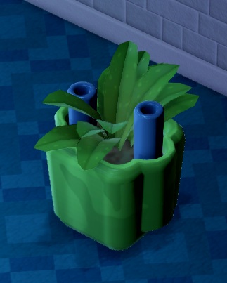 Een (plastic?) plant in een bloembak, waaruit links en rechts een blauwe bevochtigingsbuis steekt.