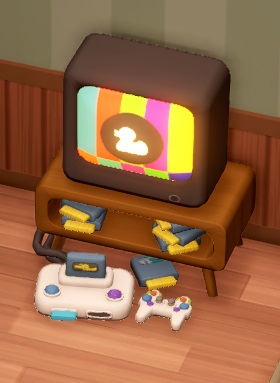 Een spelconsole, aangesloten op een televisie, met diverse spelcassettes in het kastje onder de televisie. Op het scherm is een testbeeld te zien, met middenin een wit silhouet van een eend op een zwarte, cirkelvormige achtergrond.
