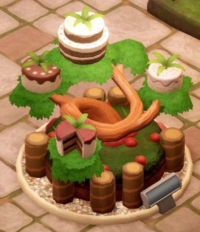 Een Cake Plant in Two Point Museum heeft, hoe kan het ook anders, taarten en cakes aan de bladeren. De hele plant lijkt op een overgroeide Bonsai-boom.