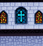 Een kapelmuur met drie glasramen. Het middelste glasraam bevat een kruisfiguur.