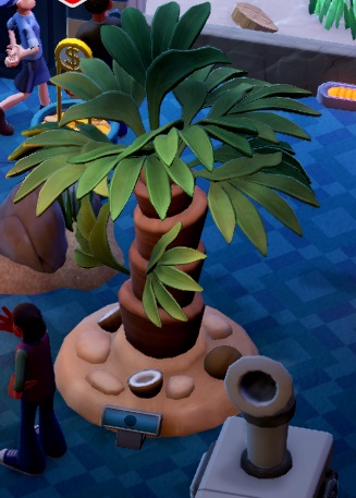 Een Palmboom ziet er in Two Point Museum weinig onrealistisch uit. De foto toont een Palm Tree, met daaronder enkele halve kokosnoten. Rechtsonder is een Luchtbevochtiger gedeeltelijk zichtbaar.
