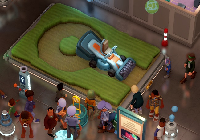In een miniatuur-graancirkel staat de Space Mower: een enorme zitmaaier... Bezoekers lopen rond de Space Mower.